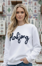 Woman wearing a white sweatshirt with 'Mahjong' text in a store setting