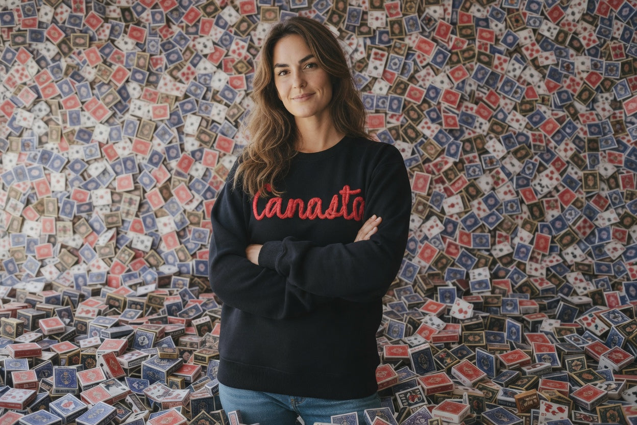 Person wearing a black sweatshirt with 'Canasto' text standing in front of a wall with small colorful flags.