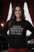 Woman wearing black sweatshirt pullover with rhinestone details text caviar champagne chocolate mahjong