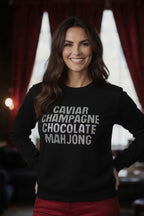 Woman wearing black sweatshirt pullover with rhinestone details text caviar champagne chocolate mahjong