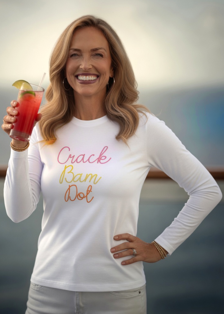 Woman holding a drink with a scenic background, she is wearing a white long sleeve with crack bam dot design for mahjong tops