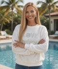 Women wearing LOVE Mahjong white sweatshirt by the pool