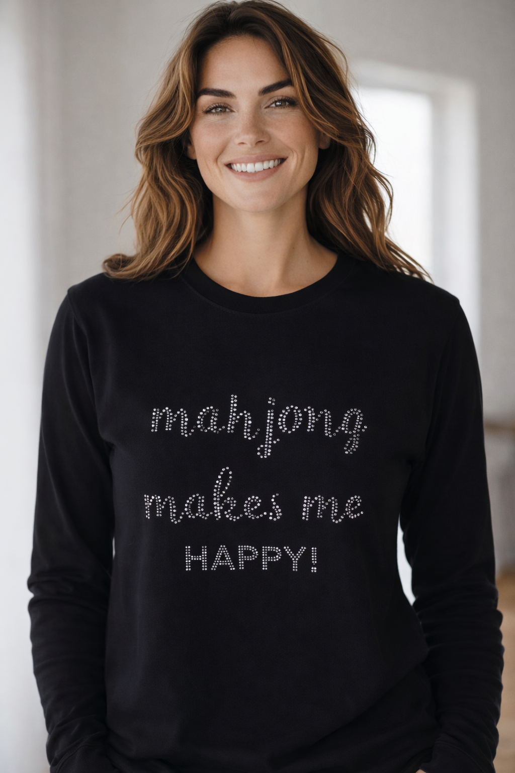 Woman wearing a black sweatshirt with 'mahjong makes me happy!' text.