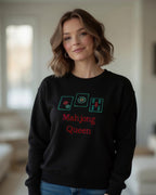 Woman wearing black sweatshirt pullover tee with embroided mahjong queen design in interior settings